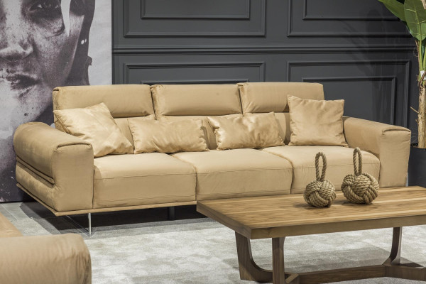 Beige dīvāns trīs vietām ar spilveniem