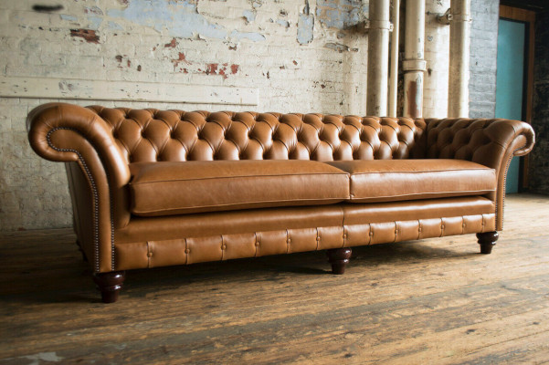 Brūns Chesterfield dīvāns, luksusa 4-vietīgā dīvāns, pārklāts ar auduma polsteri.