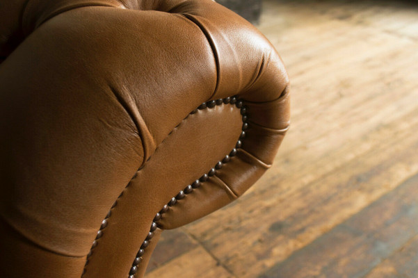 Brūns Chesterfield dīvāns, luksusa 4-vietīgā dīvāns, pārklāts ar auduma polsteri.