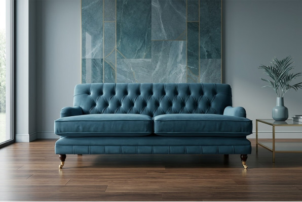 Zils mūsdienīgs Chesterfield trijosvietu luksusa dīvāns dzīvojamās istabas gultā.