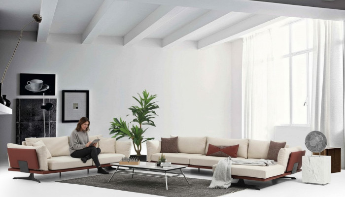 Sofas komplekts ar diviem sēdvietu stūra dīvānu L-formā, bēša krāsā, modernā audumā.