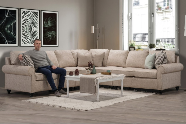 Mūsdienīgajā dzīvojamajā istabā stūra dīvāns ar L-formas dizainu, gaiši beige mēbeles, luksusa dīvāns, iekārtojums.